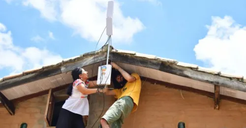 Hombre y mujer conectando una antena en una casa rural.